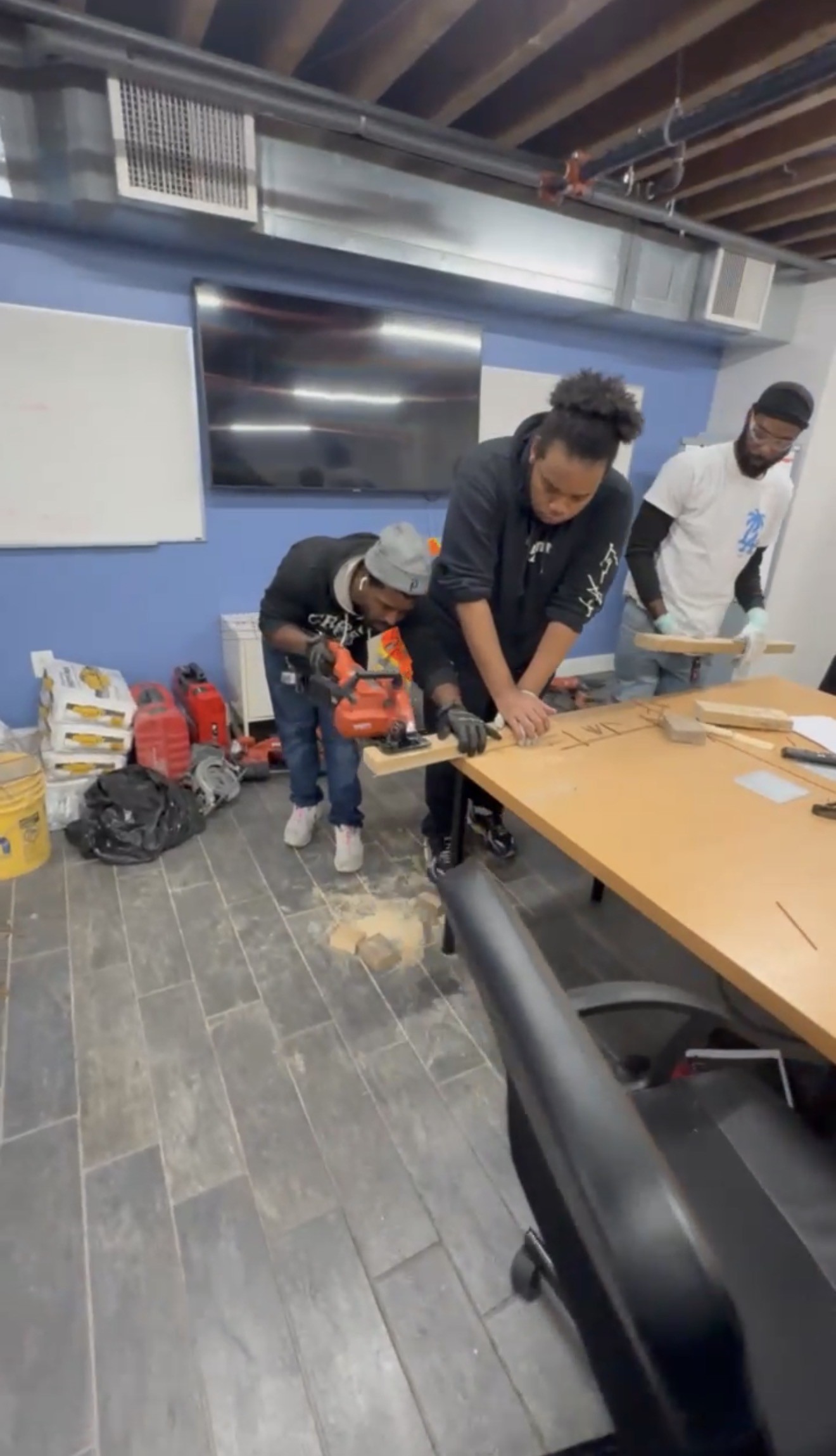 Trainees practicing power tool use with coaching in a classroom workshop